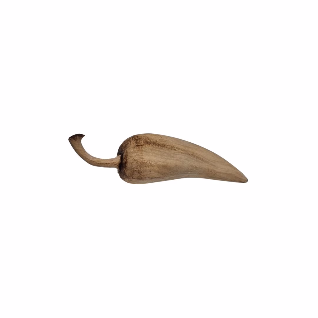 Figura decorativa con forma de ají tallada en madera, mostrando su tallo curvo y cuerpo alargado con acabado rústico en tonos café claro.
