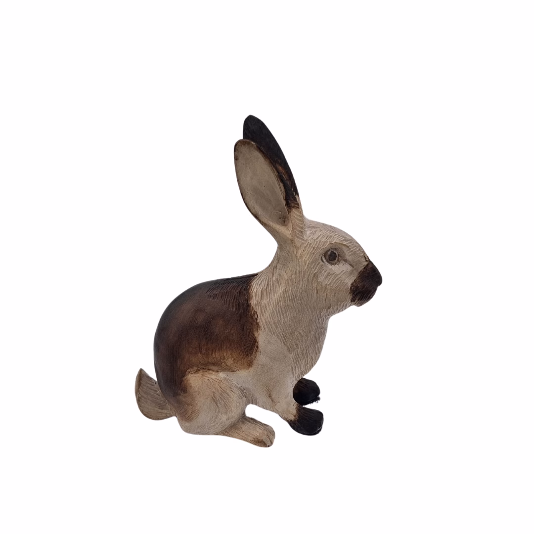Figura decorativa de un conejo mediano tallado en madera, vista de perfil con detalles texturizados en tonos café y beige.