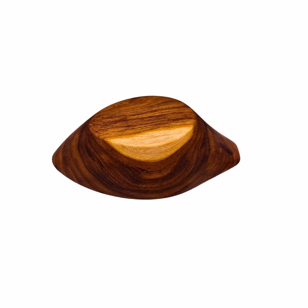 Vista inferior del cuenco de madera con forma de piñón, mostrando el fuerte contraste de colores naturales en su base plana.