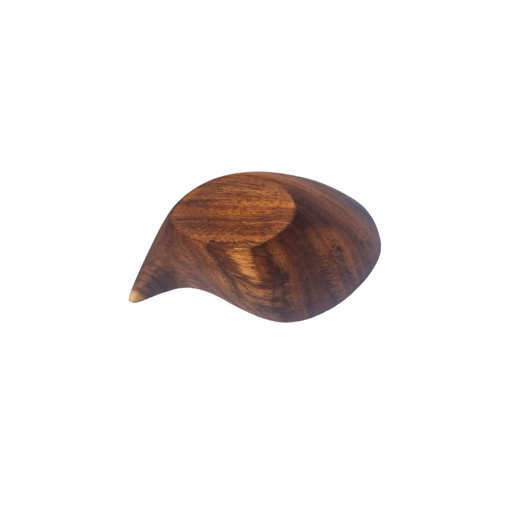 Vista inferior de la base plana de un cuenco de madera con forma de gota de agua, apoyado boca abajo.