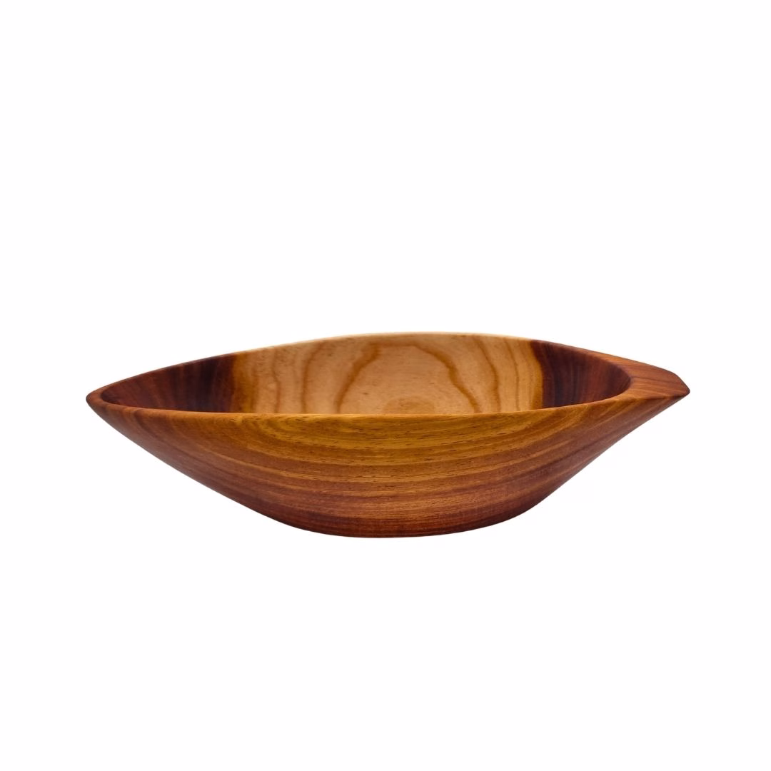 Vista lateral de un cuenco de madera tallada con forma de piñón, mostrando su base curva y diseño asimétrico sobre fondo blanco.
