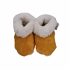 Par de pantuflas de cuero de reno color camel con un grueso borde de lana natural blanca.