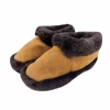Par de pantuflas de cuero de reno café claro con reborde de gruesa lana oscura.