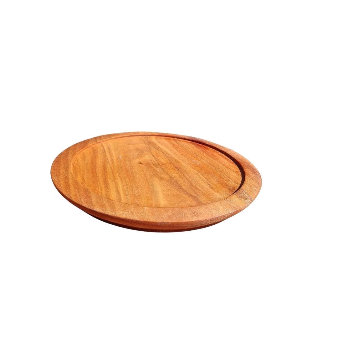 Vista en ángulo de plato redondo de madera de raulí, destacando el relieve del borde para contener alimentos.