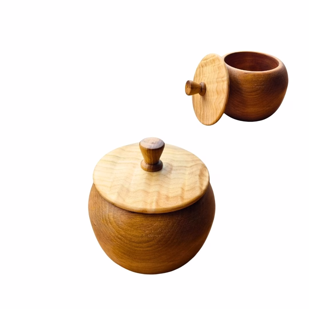 Recipiente multiuso de madera nativa de raulí con tapa texturizada clara, mostrado cerrado y abierto sobre fondo blanco.
