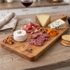 abla Multiuso ROU servida como aperitivo con diversos quesos, jamón serrano, salame, frutos secos, damascos deshidratados y copa de vino tinto sobre mesa de madera rústica.