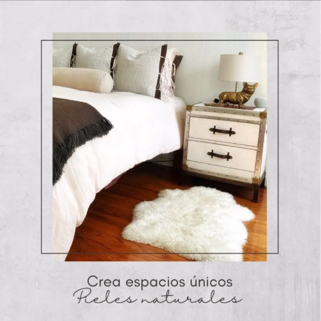Piel de oveja natural utilizada como bajada de cama sobre un piso de madera en un dormitorio decorado.