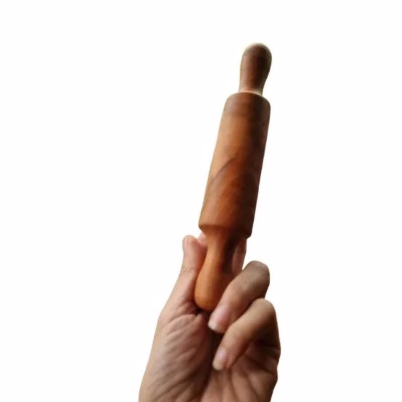 Mano de adulto sosteniendo un uslero infantil de madera de raulí para mostrar su tamaño.